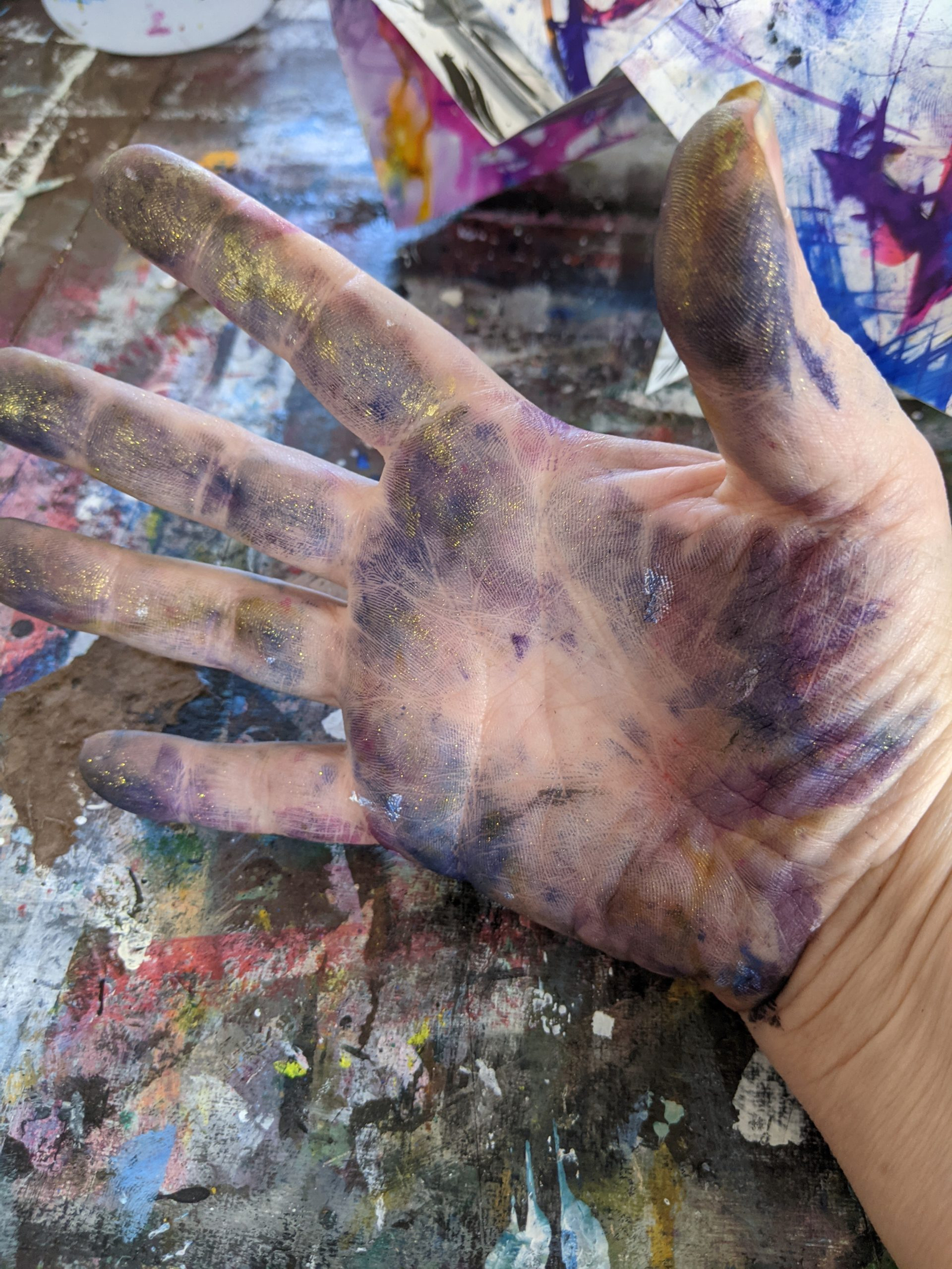 Messy hand of an artist covered in paint